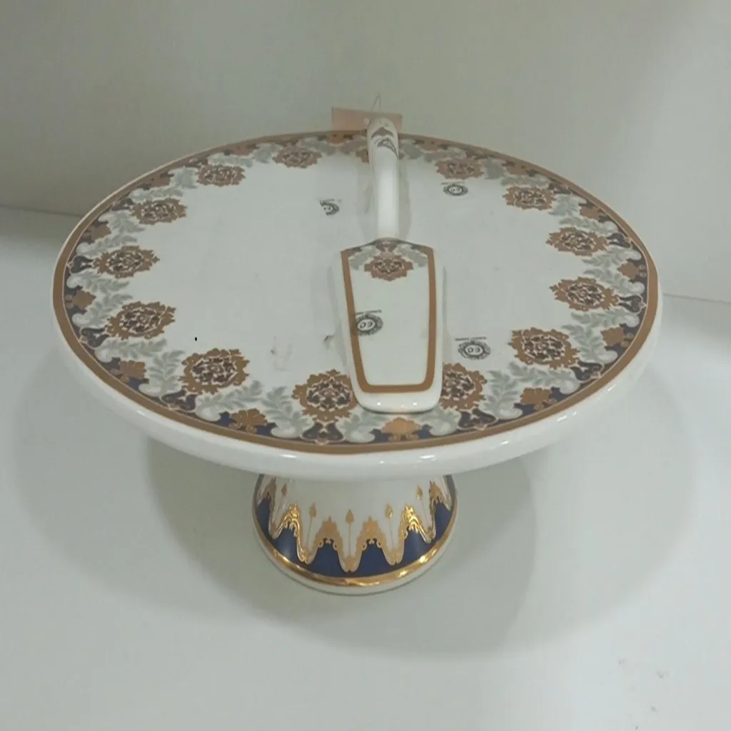Ceramic pedestal cake stand with a cake server