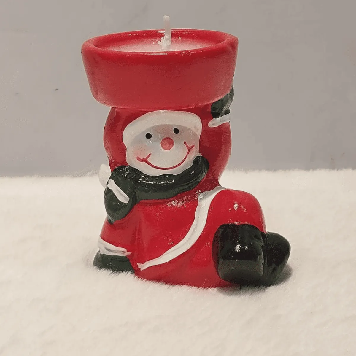 Charming snowman candle for festive ambiance.