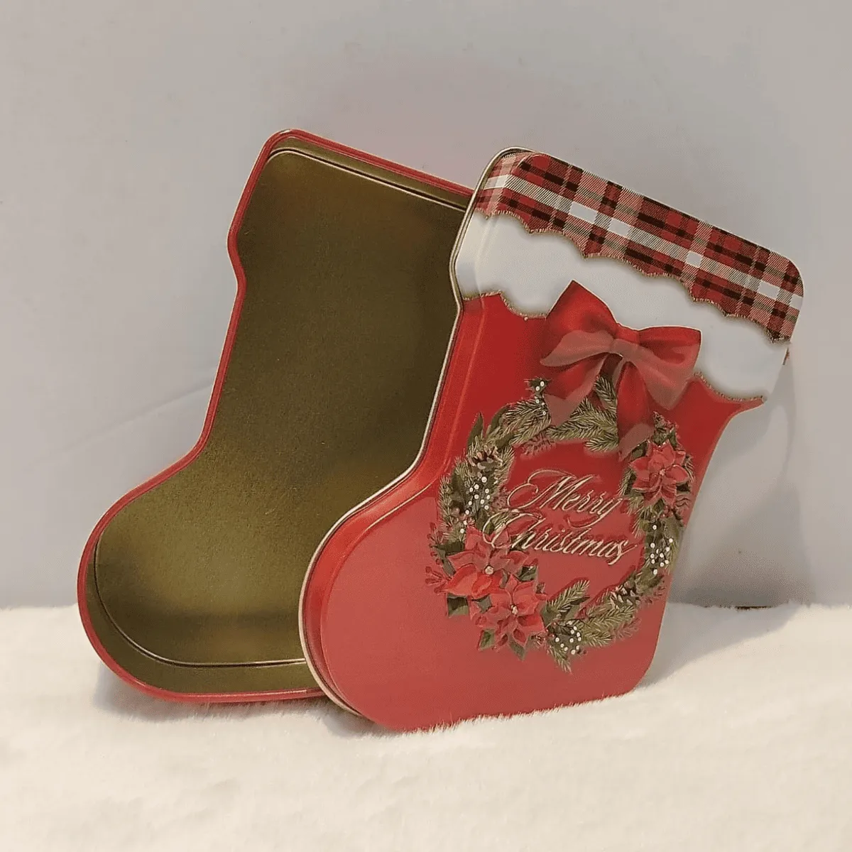 Festive stocking-shaped storage tin for gifts.